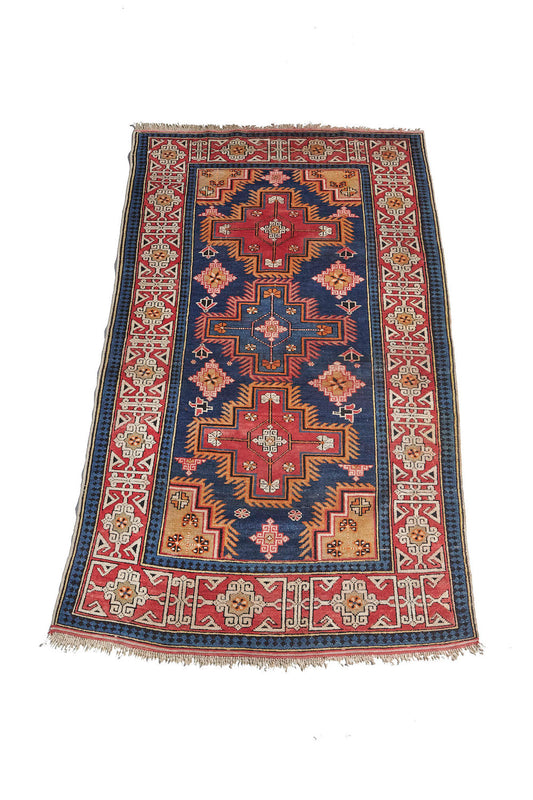 Hand woven antique Caucasian Persian rug with blue base and red, blue, pink and gold medallions. Vibrant colors. Perfect for a bedroom, kitchen, office or living room. Available from King Kennedy Rugs Los Angeles