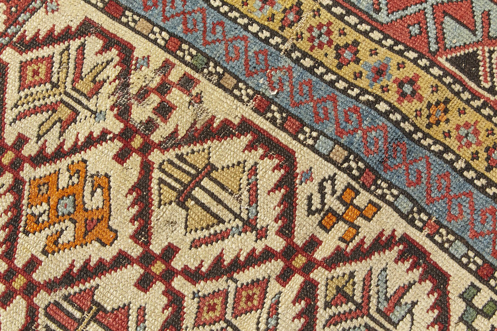 Detail of Shirvan Persian Prayer Rug. Intricately woven in beige, gold, green, blue and red with floral plant designs throughout. Perfect for a bedroom, study, bathroom or kitchen rug - Available from King Kennedy Rugs Los Angeles