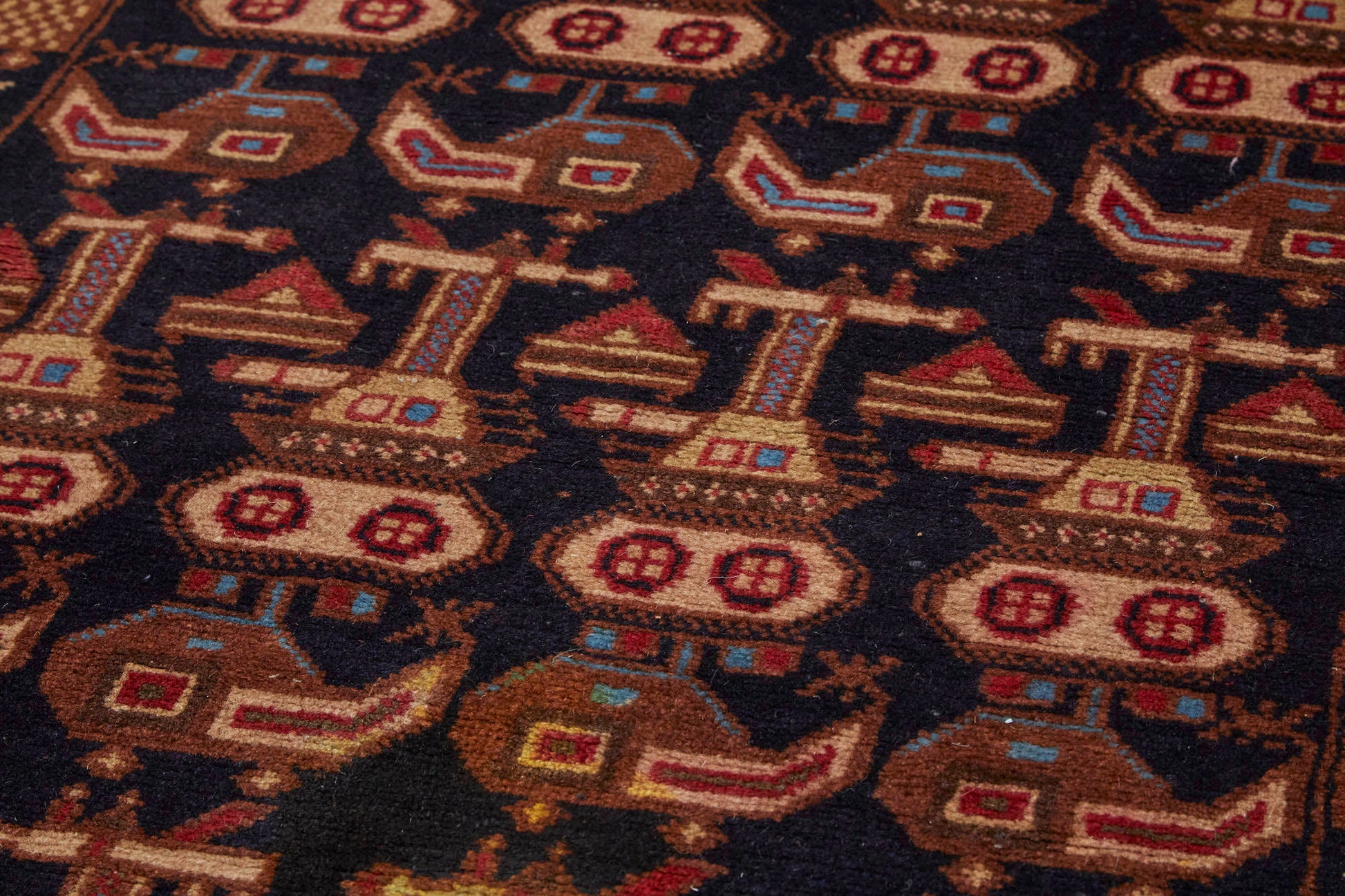 Hand woven Afghan War rug runner with dark base and tan, red and blue tanks and helicopters woven throughout - Available from King Kennedy Rugs Los Angeles