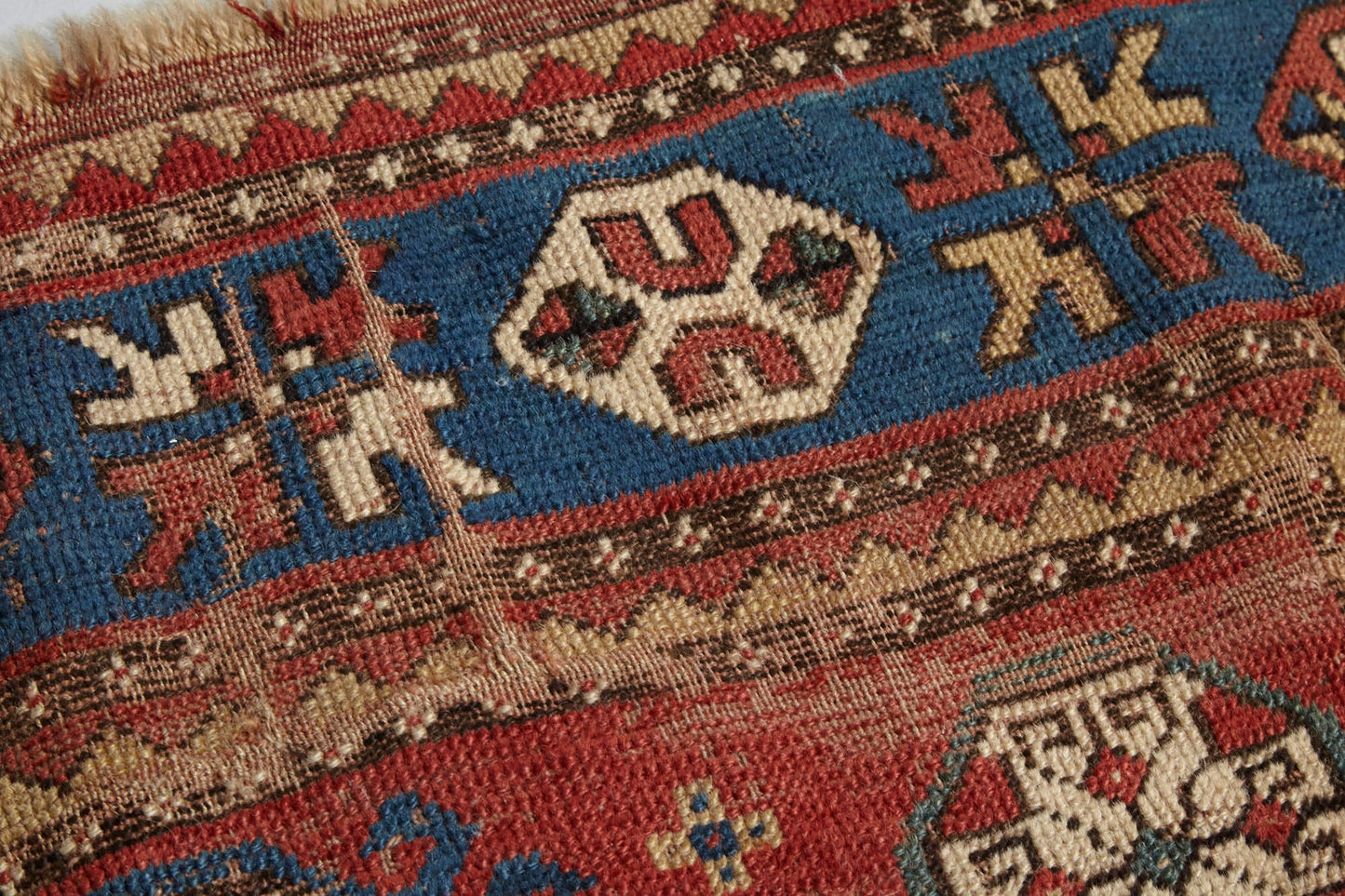 Close up of beautifully worn antique Kazak Persian Rug with red, blue and cream colors - Available from King Kennedy Rugs Los Angeles