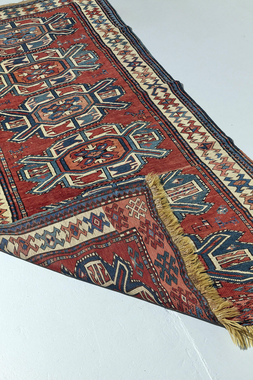 Front and back of antique hand woven Karabaugh Persian Rug with red base and multiple medallions in pink, cream and blue with white border and beautiful shapes and symbols woven throughout. A perfect addition to a bedroom, dining room or kitchen. Available from King Kennedy Rugs Los Angeles