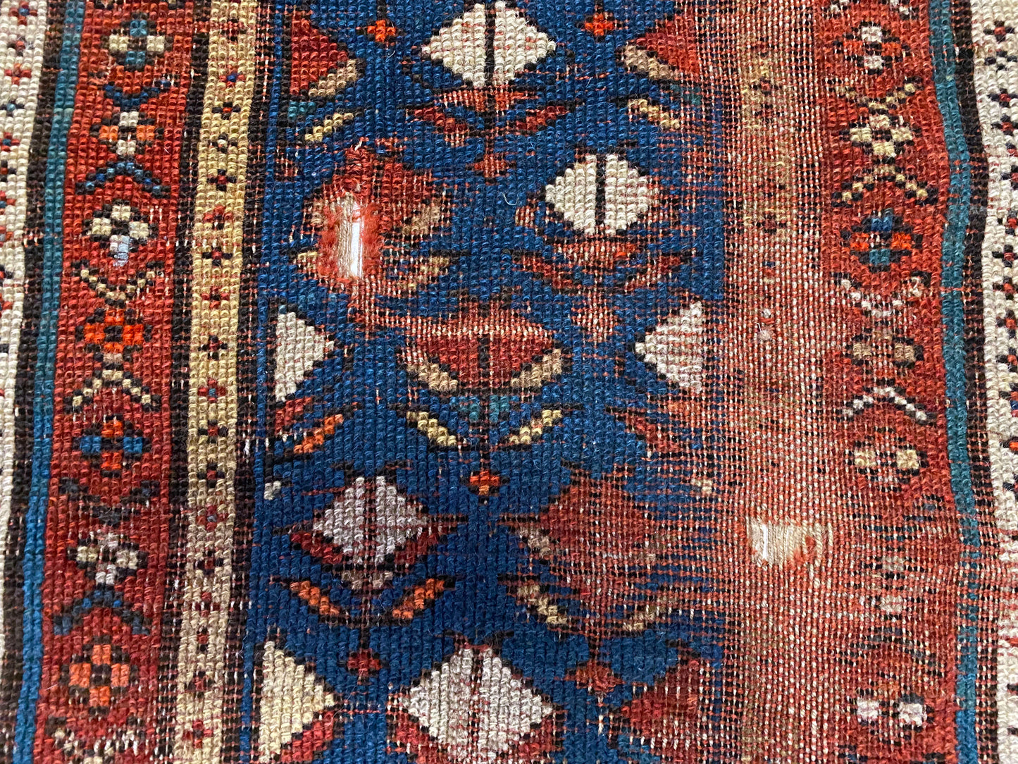 Intricately hand woven Kazak Persian rug with red, blue, orange, tan and white patterns hand woven across - Available from King Kennedy Rugs Los Angeles
