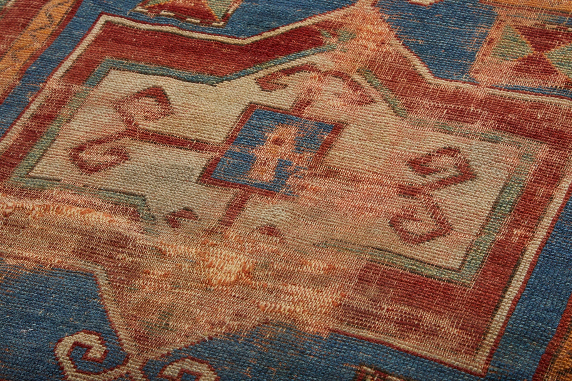 Detail of center medallion on antique Kazak Persian Rug with red, tan, blue and cream colors - Available from King Kennedy Rugs Los Angeles