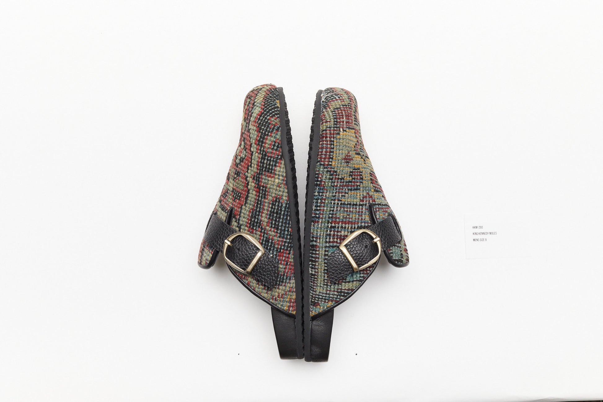 Pictured here is a buckle side view of the original King Kennedy Rug Mules.  King Kennedy Rug Mules are one-of-a-kind and made of 100 year old antique Persian rug fragments with soft lambskin footbed and rubber sole. This pair is made of an antique Persian rug with beautifully faded pattern in green, red and yellow. 