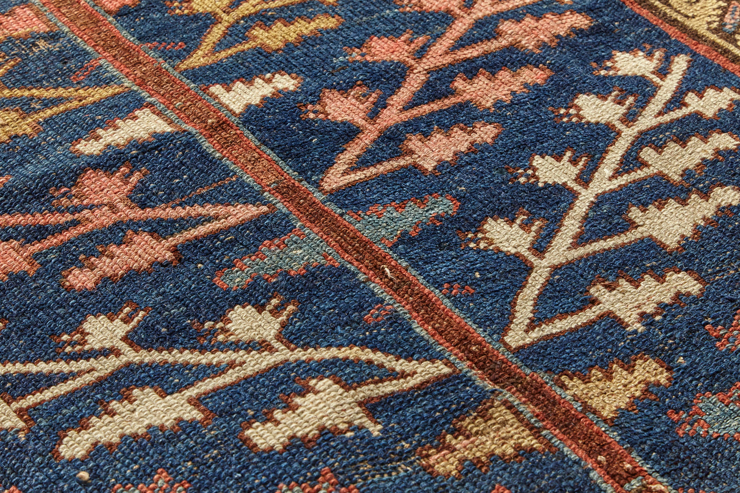 Detail of Kurdish antique Persian rug, hand woven with tree of life design on a blue background with gold, red, pink and cream branch and leaf designs throughout, would be beautiful in a bedroom, kitchen, hallway or living room - Available from King Kennedy Rugs Los Angeles