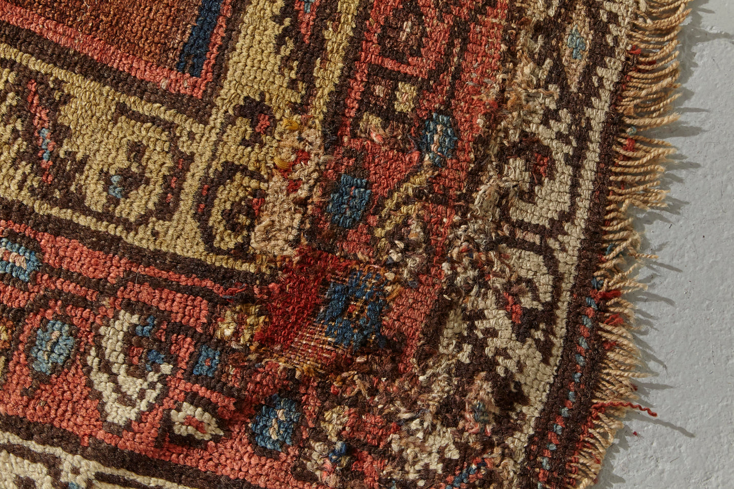 Corner detail of Kurdish antique Persian rug, hand woven with tree of life design on a blue background with gold, red, pink and cream branch and leaf designs throughout, would be beautiful in a bedroom, kitchen, hallway or living room - Available from King Kennedy Rugs Los Angeles