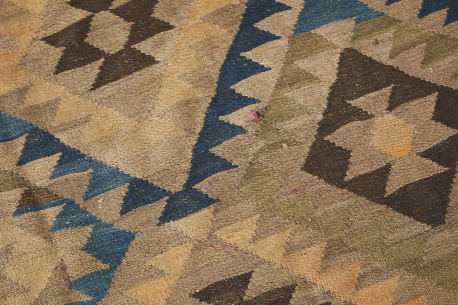 Maimana Turkish Kilim area rug with tan, beige and brown earthy tones, along with blue, cream and peach geometric patterns. Hand woven large area rug - Available from King Kennedy Rugs Los Angeles