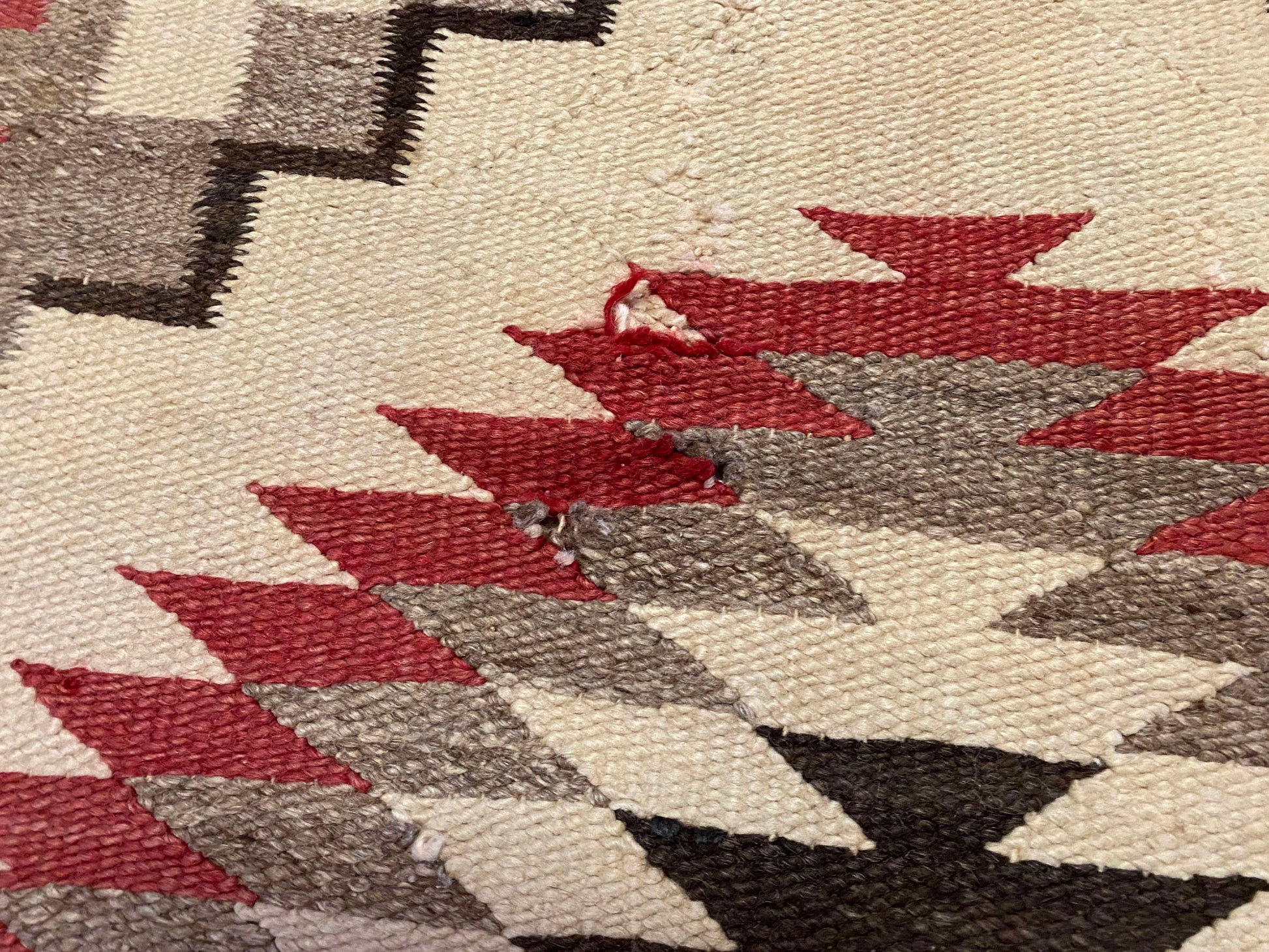 Antique Navajo rug with cream base, tan and red whirling logs and zig zag shapes, naturally dyed and hand woven - Available from King Kennedy Rugs Los Angeles