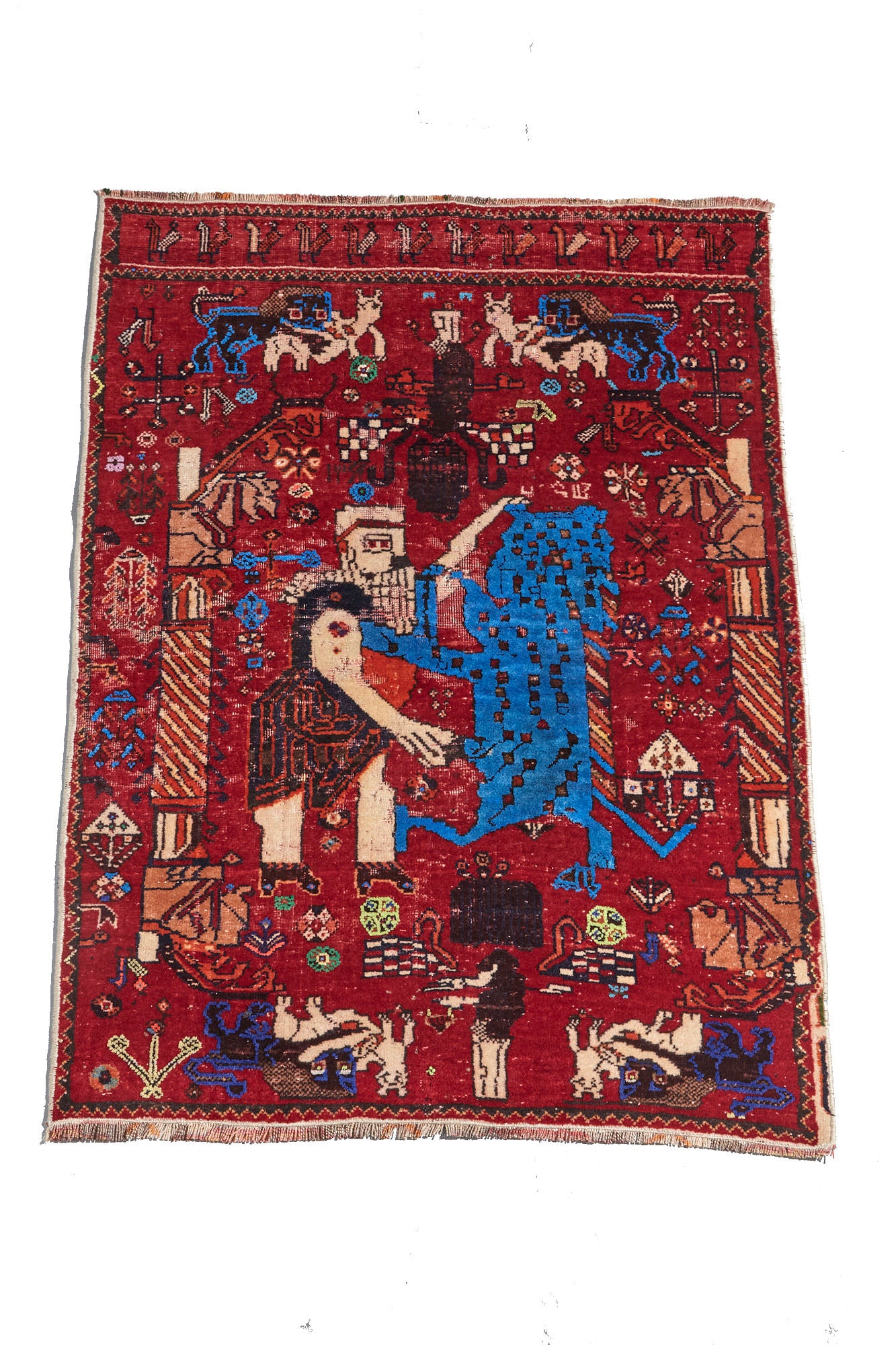 Unique and rare Persian pictorial hand woven rug with red base depicting a man wrestling a lion. Vibrant red and blue tones with cream, green and tan details. Perfect for study, living room, or wall hanging. Available from King Kennedy Rugs Los Angeles