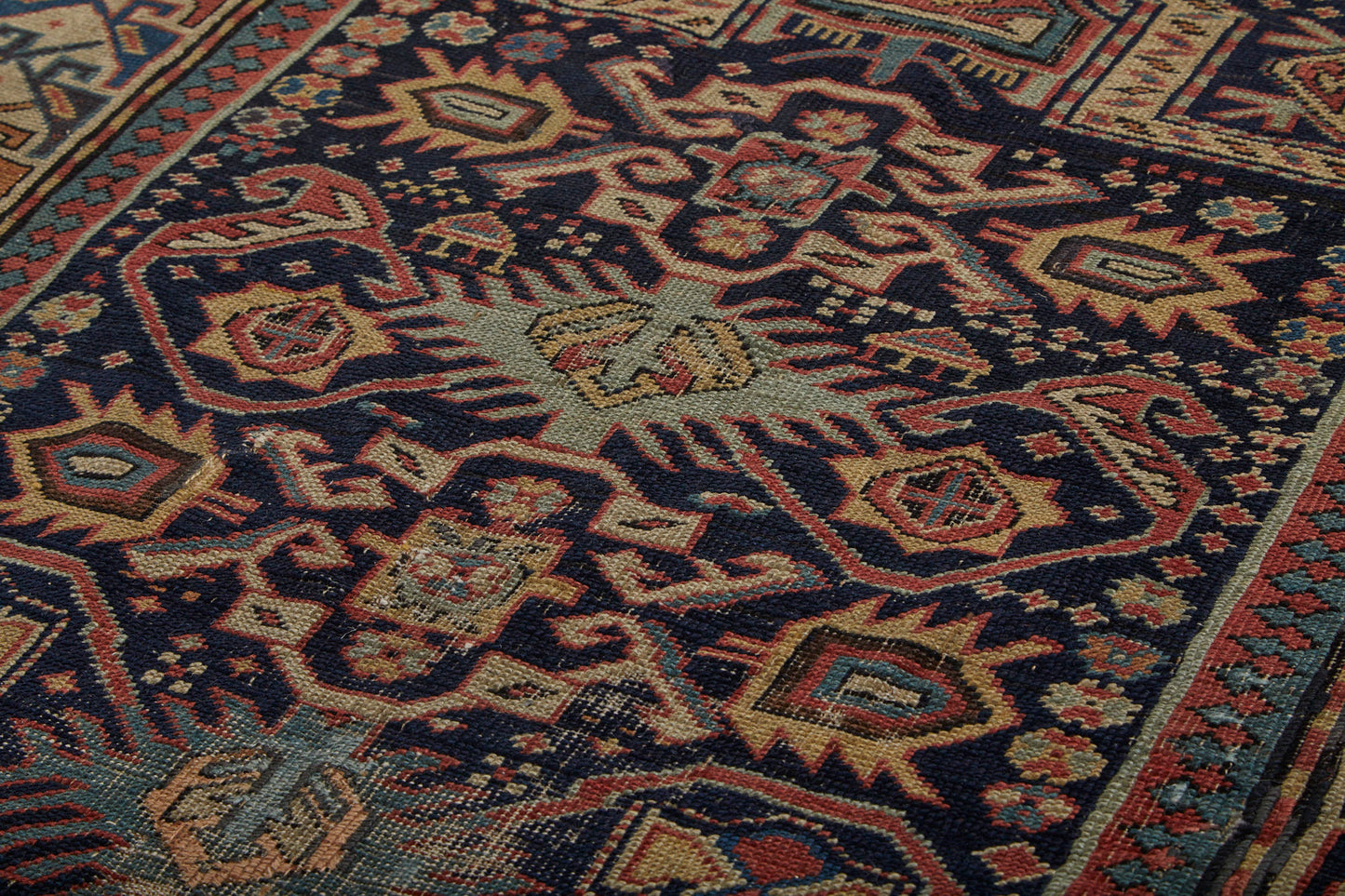 Antique Shirvan Prayer Persian rug intricately hand woven with beige base, dark blue center and yellow, pink and pale blue designs throughout with some repairs - Available from King Kennedy Rugs Los Angeles