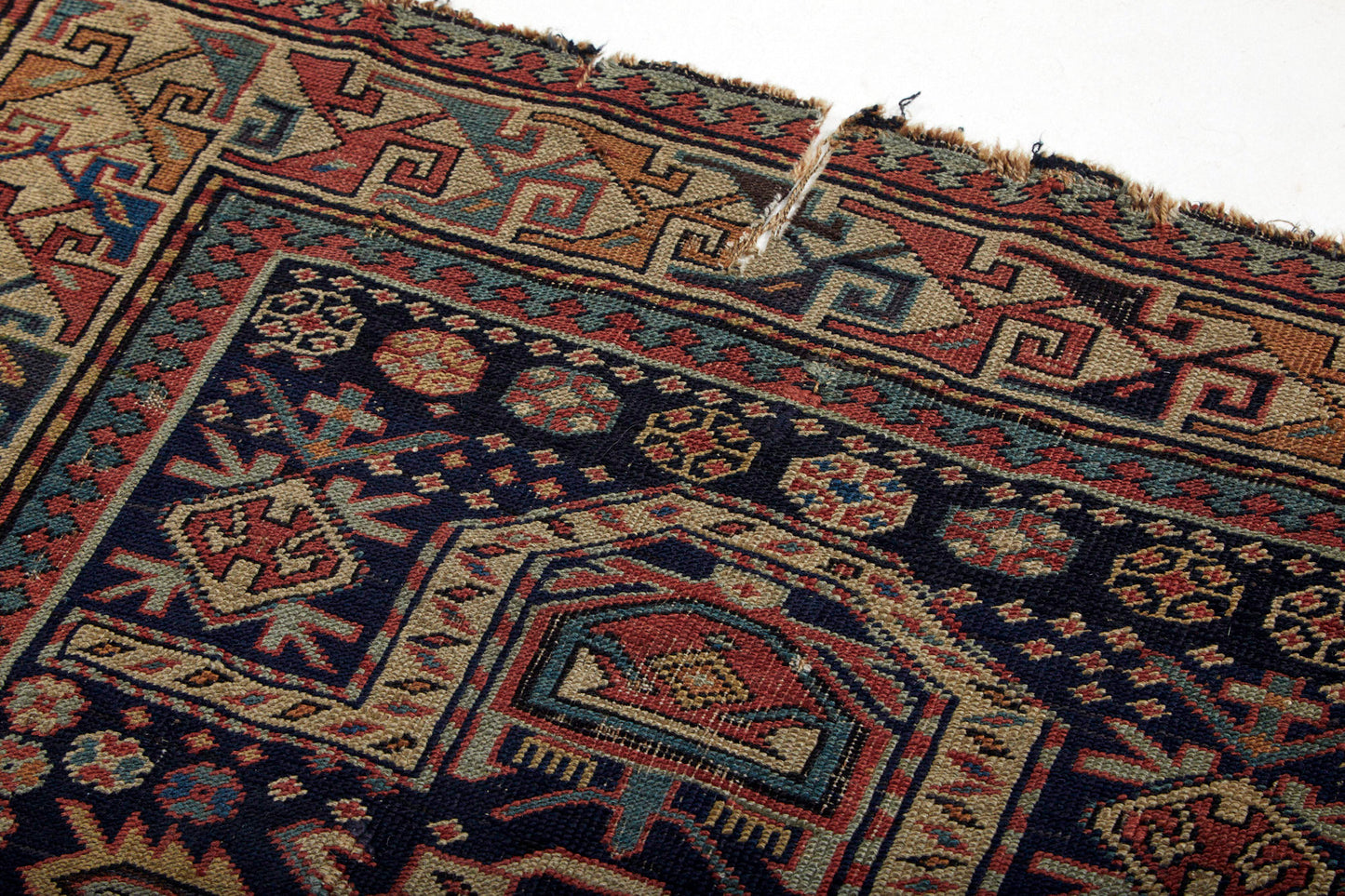 Antique Shirvan Prayer Persian rug intricately hand woven with beige base, dark blue center and yellow, pink and pale blue designs throughout with some repairs - Available from King Kennedy Rugs Los Angeles
