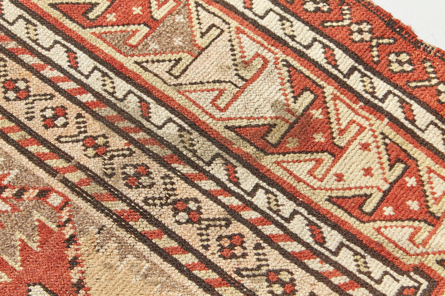 Detail of hand woven antique Shirvan Prayer rug, beige tan base with red, peach and brown designs throughout. Perfect for a bedroom, office, living room or as a wall hanging - Available from King Kennedy Rugs Los Angeles