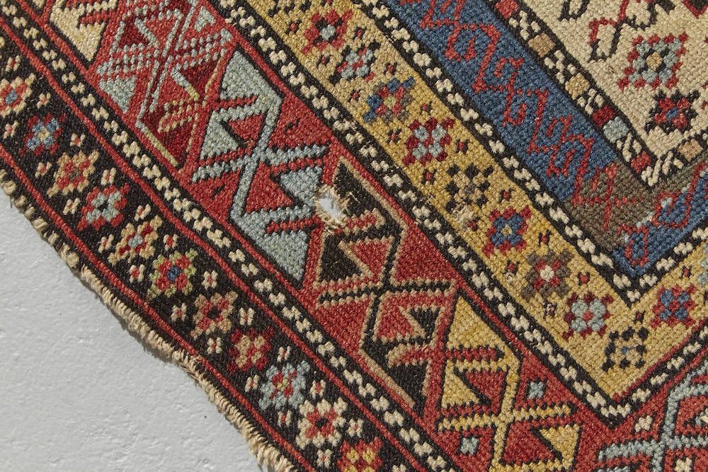 Border detail of Shirvan Persian Prayer Rug. Intricately woven in beige, gold, green, blue and red with floral plant designs throughout. Perfect for a bedroom, study, bathroom or kitchen rug - Available from King Kennedy Rugs Los Angeles